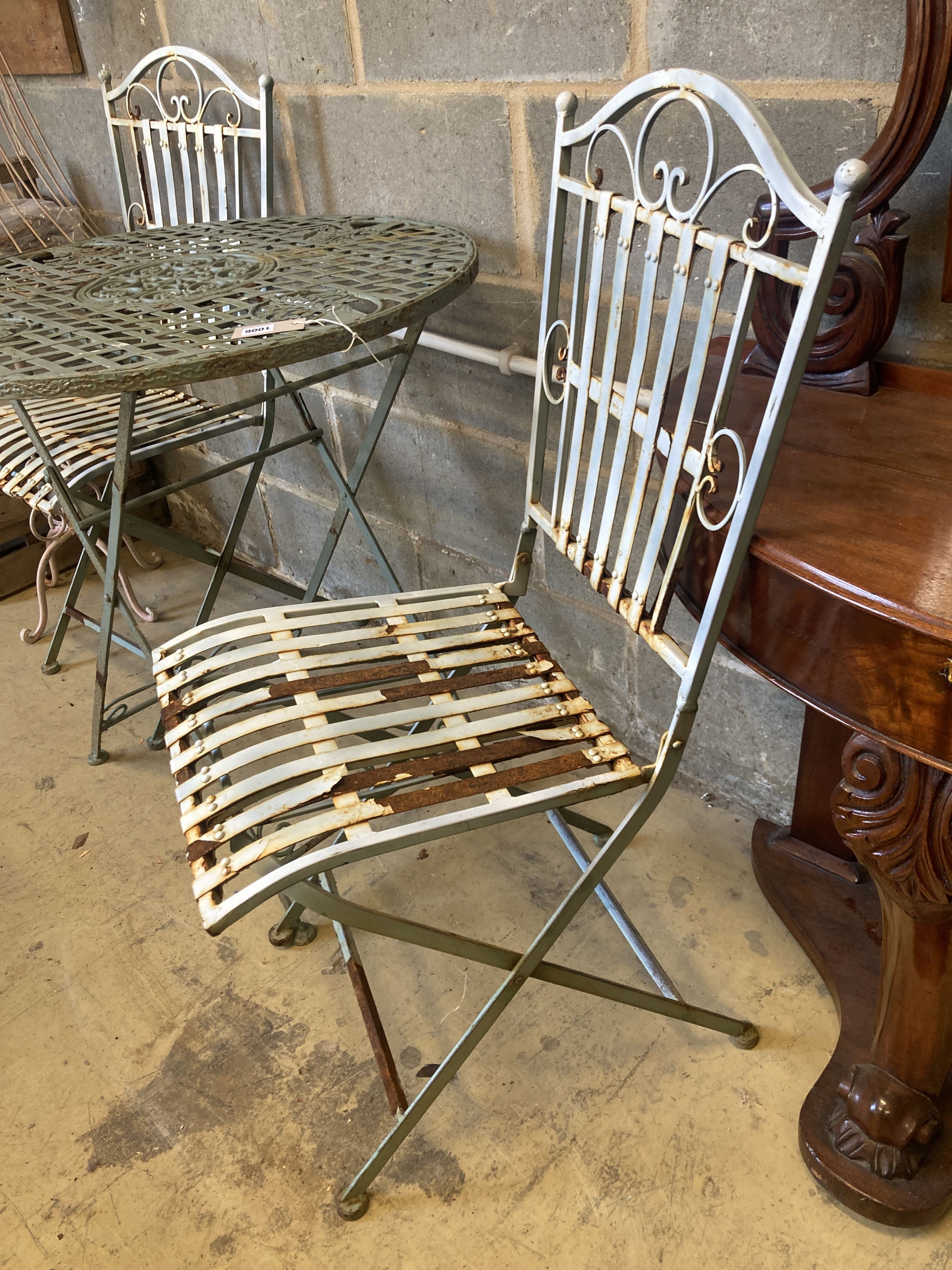 A painted circular aluminium folding garden table, 71cm diameter, height 76cm, together with a pair of folding garden chairs